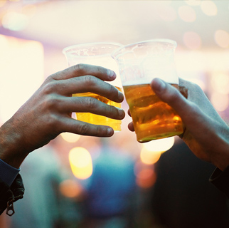 Primer plano de dos vasos de cerveza chocando.